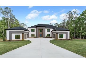 Beautiful home exterior with attached two-car garages, long driveway, and well-manicured lawn at 2843 N North Bogan Rd, Buford, GA 30519