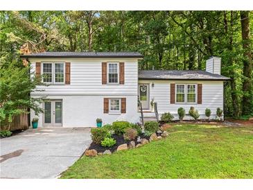 Charming home with white siding, brick accents, manicured lawn, and beautiful landscaping at 4723 N Springs Nw Rd, Kennesaw, GA 30144