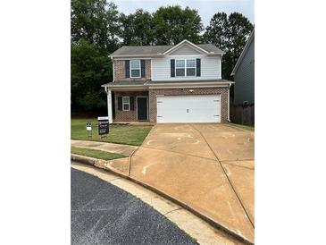 Charming two-story home featuring a brick facade, neutral siding, and a well-maintained lawn at 10786 Wheeler Trce, Hampton, GA 30228