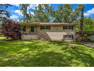 Charming two-story brick home with a well-maintained front yard and mature trees at 14300 Veterans Memorial Highway, Villa Rica, GA 30180