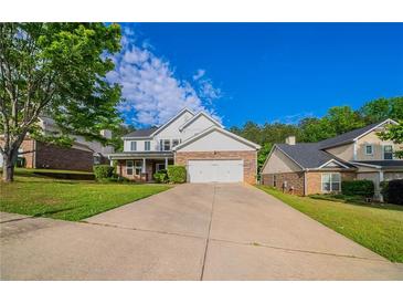 Charming two-story home with a brick and white facade and a well-manicured front yard at 3460 Village Park Sw Ln, Atlanta, GA 30331