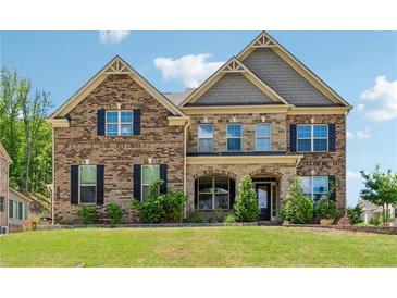 Traditional two-story brick home with a manicured lawn and black shutters, offering classic curb appeal at 2410 Bridle Bridge Trl, Cumming, GA 30040