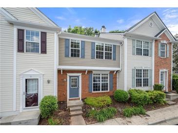 Charming townhome featuring classic architecture and a welcoming front garden area at 1135 Kilmington Ct, Alpharetta, GA 30009