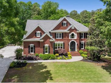 Elegant brick home featuring manicured landscaping and a classic architectural design at 10410 High Falls Cir, Alpharetta, GA 30022