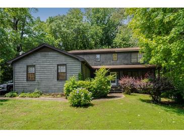 Charming two-story home with landscaped yard and mature trees in a serene, wooded setting at 1429 Smithson Dr, Lithonia, GA 30058
