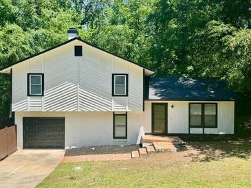 Charming two-story home featuring a black roof, white siding, and a neatly maintained front yard at 3988 Chimney Ridge Dr, Ellenwood, GA 30294