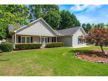 Charming single story home with manicured lawn, mature trees, and inviting front porch at 130 Lacey Oak Ln, Loganville, GA 30052