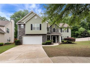 Charming two-story home with a two-car garage, landscaped front yard, and a combination of siding and stone exterior at 3265 Watson Gate Rd, Loganville, GA 30052