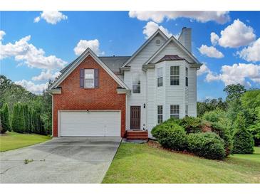 Charming two-story home features brick and vinyl siding with an attached two-car garage at 1405 Bramlett Forest Trl, Lawrenceville, GA 30045