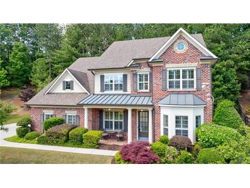 Charming two-story brick home with a covered front porch and beautifully landscaped yard at 621 Oakbourne Way, Woodstock, GA 30188