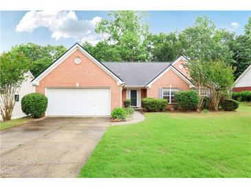 Charming single-story brick home with a well-manicured lawn and an attached two-car garage at 75 Saltcreek Pt, Sugar Hill, GA 30518