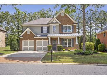 Charming two-story brick home with a well-manicured lawn, a two-car garage, and a welcoming front porch at 4765 Silver Leaf Dr, Cumming, GA 30040