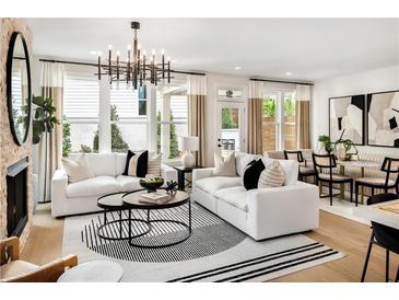 Bright living room features large windows, fireplace, modern chandelier, and open floor plan at 1248 Windmill Pkwy # 240, Cumming, GA 30041