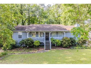 Charming single-story home with a welcoming front porch and a beautifully landscaped front yard at 6595 Oakwood Dr, Douglasville, GA 30135
