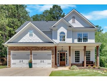 Beautiful two-story home featuring stone accents, a two-car garage, and a welcoming front porch at 209 Wildwood Way, Canton, GA 30114