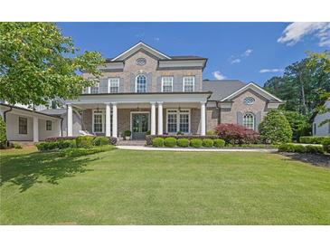 Stunning two-story brick home with a manicured lawn and a welcoming front porch with stately columns at 3264 Andante Ne Dr, Marietta, GA 30062