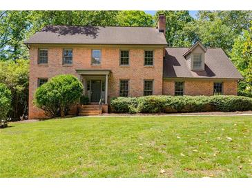 Charming brick two-story home with mature landscaping and a well-manicured lawn at 5124 Vermack Rd, Dunwoody, GA 30338