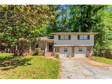 Split-level home featuring a brick and siding facade, front porch, and a two-car garage at 802 San Miguel Dr, Stone Mountain, GA 30083