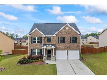 Beautiful two-story brick home featuring a two-car garage, manicured lawn, and inviting curb appeal at 548 Azalea Bloom Drive E, Loganville, GA 30052