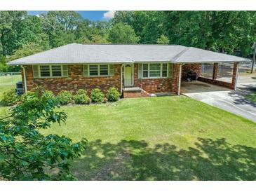 Charming brick home with a covered carport and a lush green lawn at 232 Hembredge Dr, Canton, GA 30115
