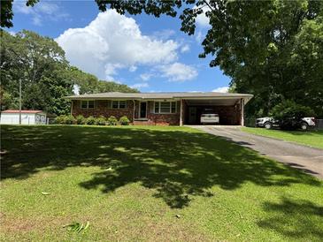 Charming brick home with well-manicured lawn and a convenient carport for covered parking at 232 Hembredge Dr, Canton, GA 30115