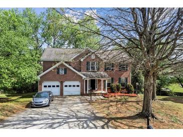 Traditional two-story brick home featuring a two-car garage, manicured landscaping, and a long driveway at 531 Chadborn Ct, Lawrenceville, GA 30045