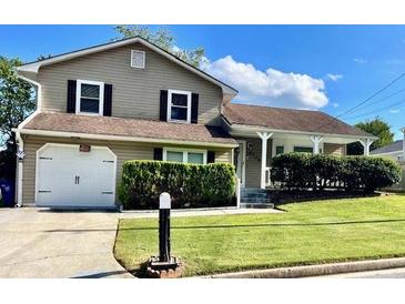 Charming home with a well-maintained lawn, an attached garage, and a cozy front porch at 6325 Stablewood Way, Lithonia, GA 30058