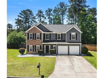 Charming two-story home features a brick and gray facade, well-manicured lawn, and a two-car garage at 209 Courtland Oaks Sw Dr, Marietta, GA 30060