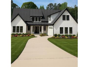 Beautifully landscaped home featuring a bright yard, dark framed windows, double-door entry, and neutral-toned driveway at 101 Deer Canyon Dr, Auburn, GA 30011
