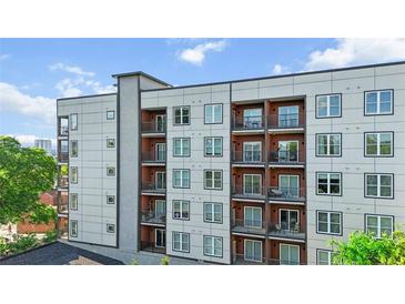 Modern apartment building with multiple floors, balconies, and large windows, situated beneath a blue sky with scattered clouds at 525 Parkway Ne Dr # 110, Atlanta, GA 30354