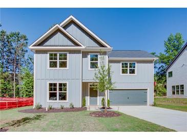 Charming two-story home with gray siding, attached garage, and well manicured lawn on a sunny day at 3352 Landings South Dr, Atlanta, GA 30331
