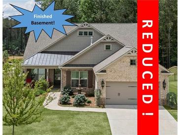 Charming home with manicured lawn, fountain, neutral brick, and attached garage is now REDUCED at 438 Southland Cir, Canton, GA 30115