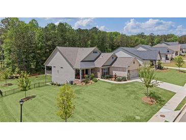 Charming single-story home featuring a beautifully landscaped lawn, a fountain, and inviting front porch seating at 438 Southland Cir, Canton, GA 30115