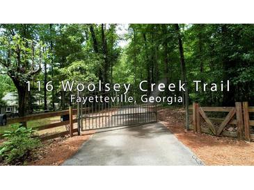 Long driveway with gated entrance leads to a wooded property at 116 Woolsey Creek Trail, Fayetteville, Georgia at 116 Woolsey Creek Trl, Fayetteville, GA 30215