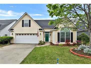 Charming home featuring a well-manicured lawn, attached garage and a beautifully landscaped front yard at 121 St Albans Way, Peachtree City, GA 30269