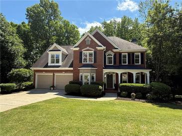 Charming two-story brick home with a manicured lawn, two-car garage, and inviting front porch at , Woodstock, GA 30189