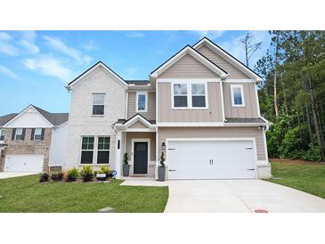 Beautiful two-story home with a manicured lawn, attached two car garage, and appealing neutral color palette at 20 Geranium Ln, Covington, GA 30016