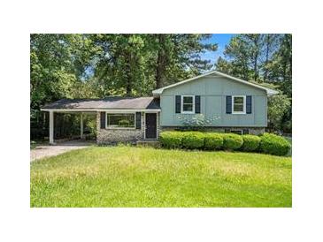 Charming home featuring a carport, stone accents, and lush landscaping, blending natural beauty with architectural detail at 170 Peachtree Ct, Riverdale, GA 30274