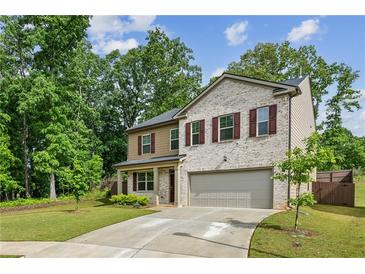 Inviting two-story home boasts a well-manicured lawn and attached two-car garage at 5320 Flat Rock Pt, Lithonia, GA 30038