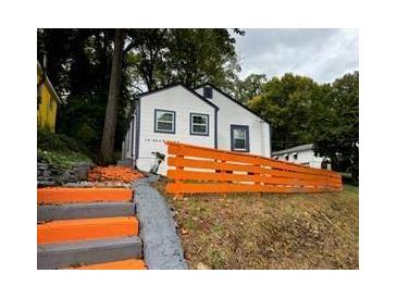 Exterior angle featuring a charming, light-colored house with an orange painted fence at 10 Rockmart Nw Dr, Atlanta, GA 30314