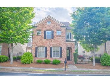 Charming two-story brick home with a well-manicured front yard and black shutters at 4448 Tacoma Trce, Suwanee, GA 30024