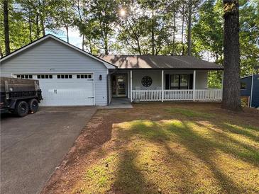 Charming home featuring a covered porch with white railings and a convenient attached two-car garage at 4771 Pinefield Nw Dr, Acworth, GA 30102