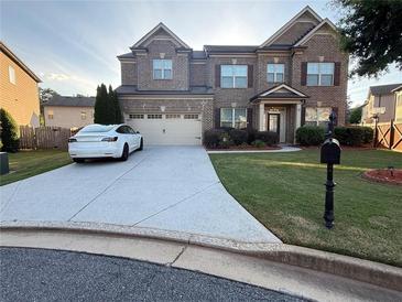 Beautiful two-story brick home with a well-maintained lawn and long driveway at 3670 Kissell Dr, Cumming, GA 30041