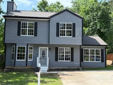 Two-story home featuring a well-manicured lawn, gray siding, black shutters, and modern windows at 615 Waynes Se Ct, Atlanta, GA 30354