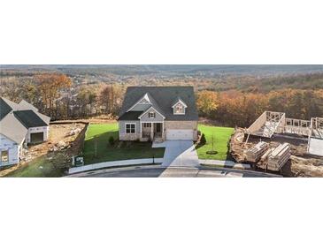 Charming new construction home with stone accents, lush lawn and a sprawling forest backdrop at 231 Laurel Vista Dr, Canton, GA 30114