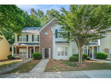 Charming townhome with a brick facade, well-manicured lawn, and inviting front porch, perfect for relaxing outdoors at 2735 Snapfinger Mnr, Decatur, GA 30035