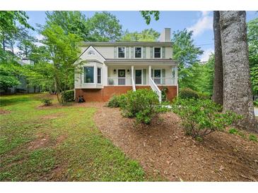 Charming two-story home with a brick foundation, a well-manicured lawn, and mature trees at 3306 Emory Dr, Marietta, GA 30062