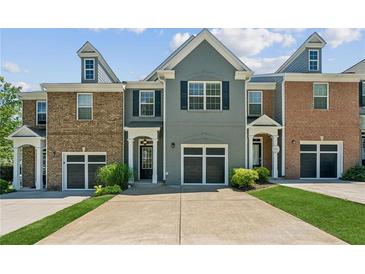 Charming townhome with a well-manicured lawn and attached garage at 5221 Sherwood Way, Cumming, GA 30040