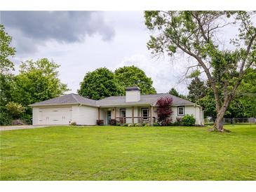 Charming home with a well-manicured lawn, mature trees, and an attached two-car garage at 7925 Silversmith Dr, Cumming, GA 30028