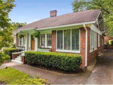 Charming brick home with a welcoming entrance, manicured hedges, and beautiful stained glass windows at 239 Kings Hwy, Decatur, GA 30030